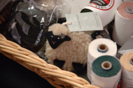 Cute toy sheep in basket of linen yarn.